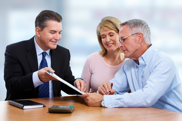Senior couple with insurance agent. Financial advisor educates wealthy couple on smart tax planning strategies.