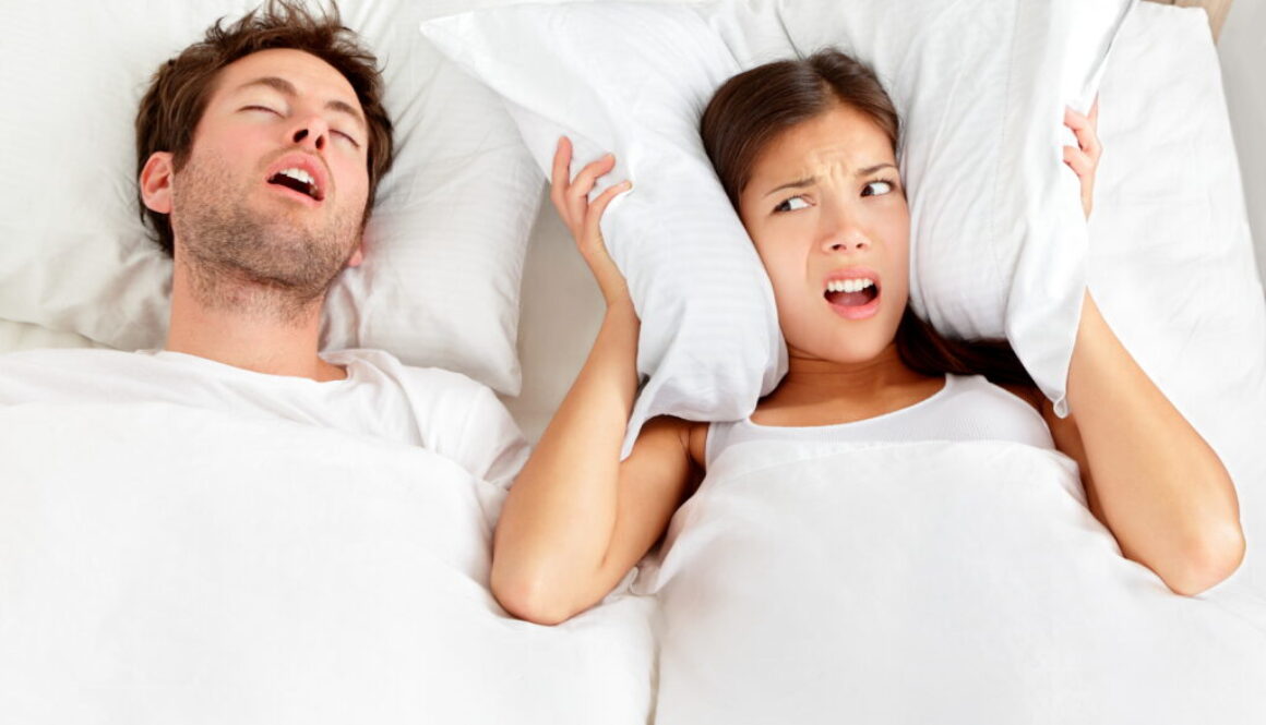 Couple in bed with the man having sleep apnea