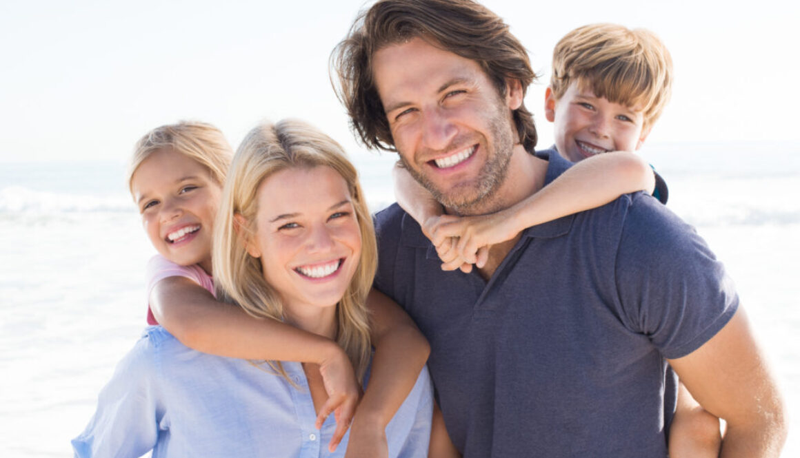 Young happy couple with two kids happy they qualify for $5M life insurance without exam or labs