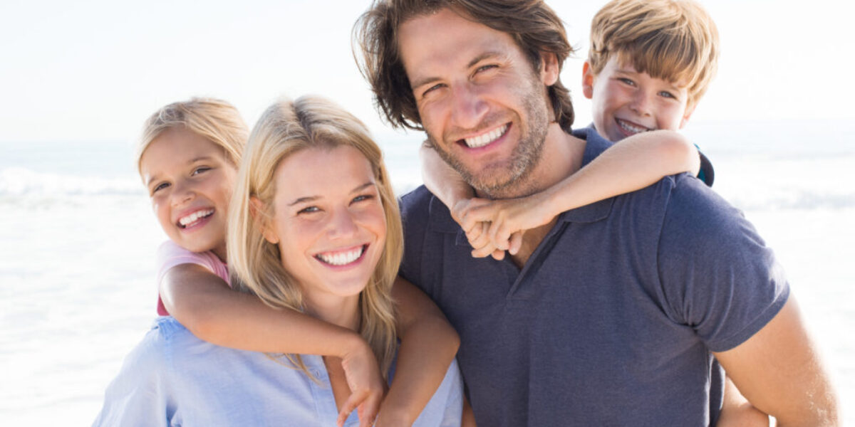 Young happy couple with two kids happy they qualify for $5M life insurance without exam or labs