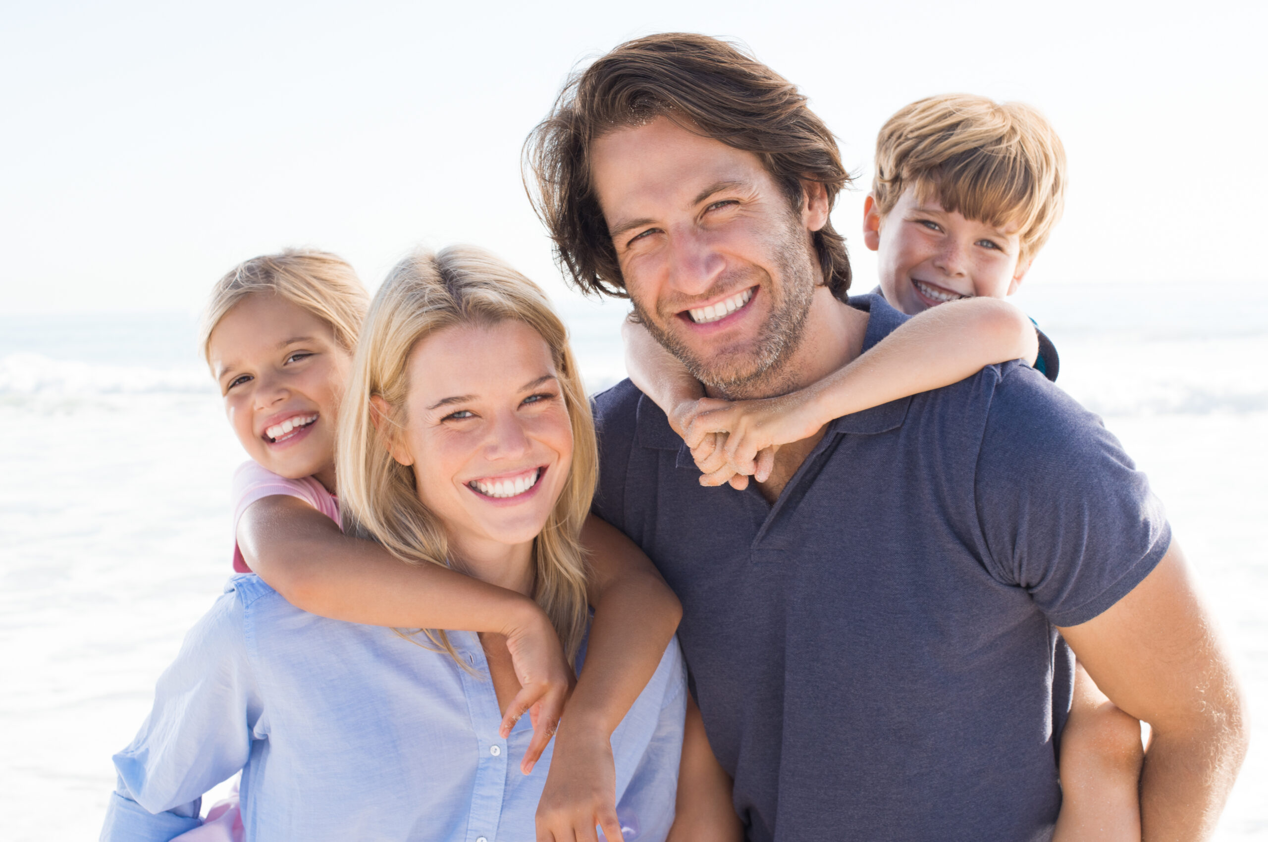 Young happy couple with two kids happy they qualify for $5M life insurance without exam or labs