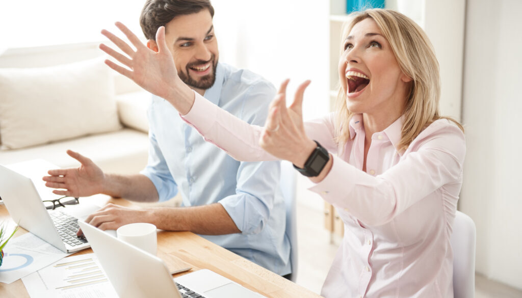 Young woman and man looking at their computers with excitement since they have just learned about Finding Ideal Prospects on LinkedIn For Free