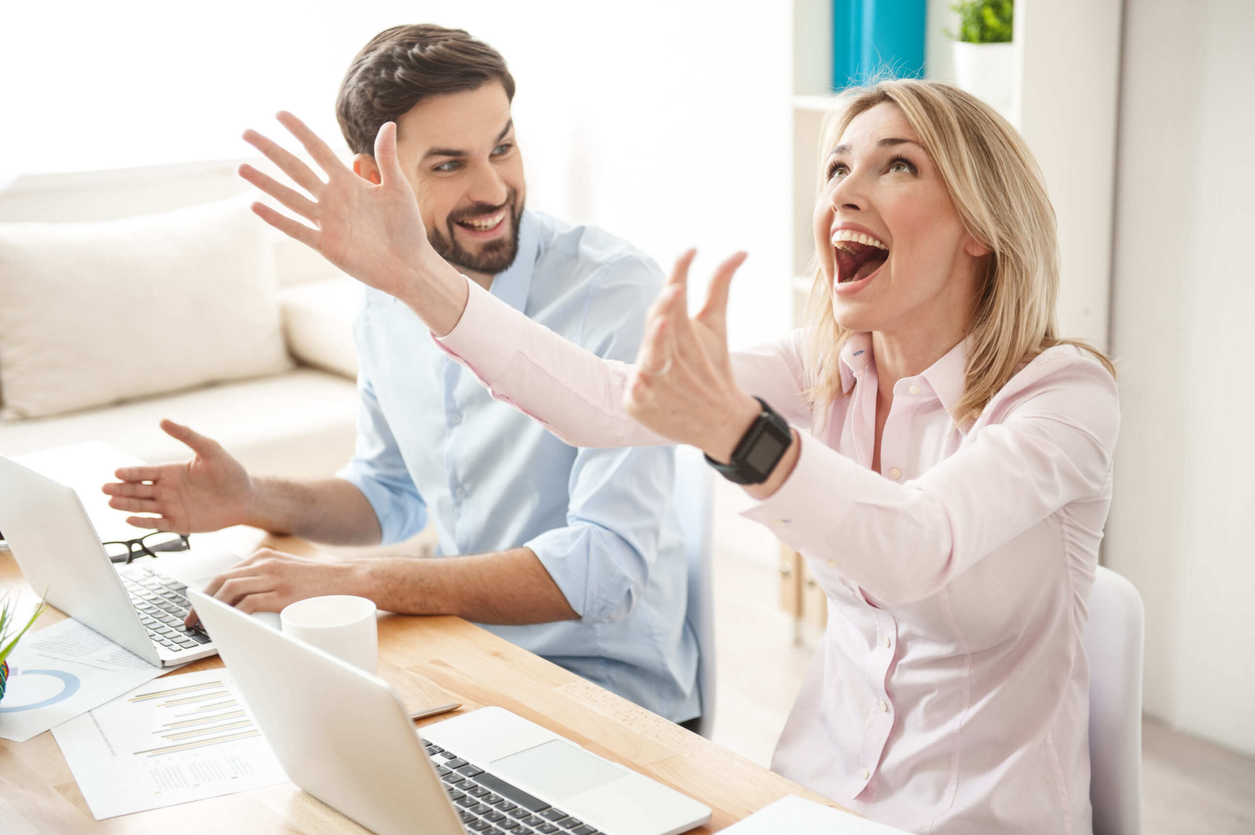 Young woman and man looking at their computers with excitement since they have just learned about Finding Ideal Prospects on LinkedIn For Free
