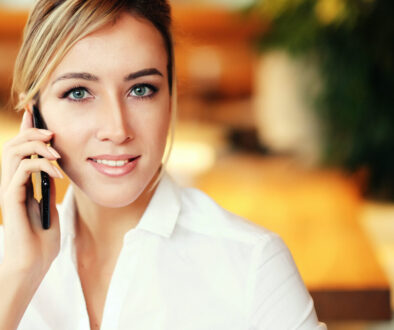 Young professional woman on her cell phone who just learned how to Quickly Build Rapport with New Ideal Prospects