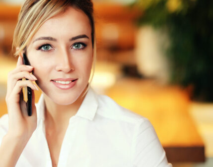 Young professional woman on her cell phone who just learned how to Quickly Build Rapport with New Ideal Prospects