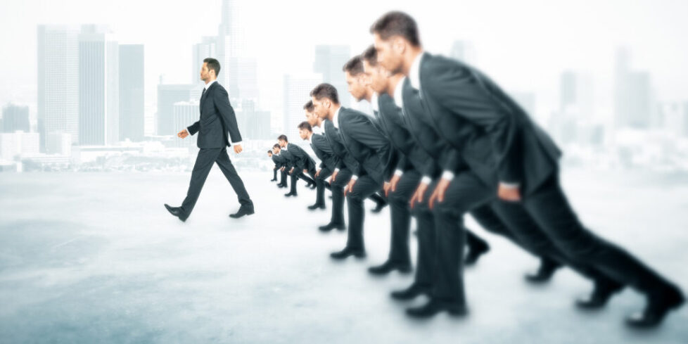 The specialist's advantage is illustrated by a leading business man confidently in front of a pack of other business men