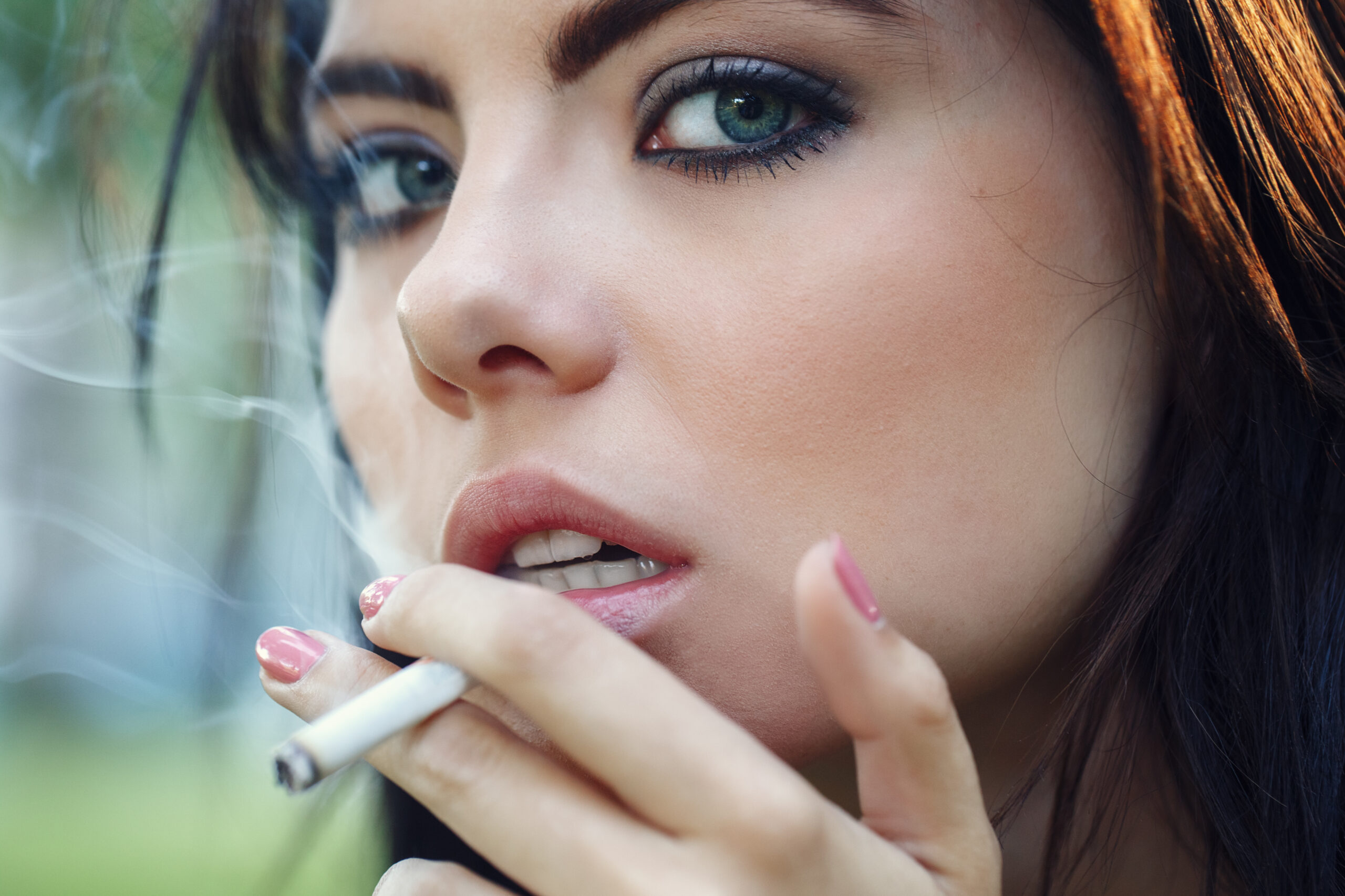 Closeup portrait of white Caucasian beautiful young sexy brunett Female tobacco user cigarette smoker