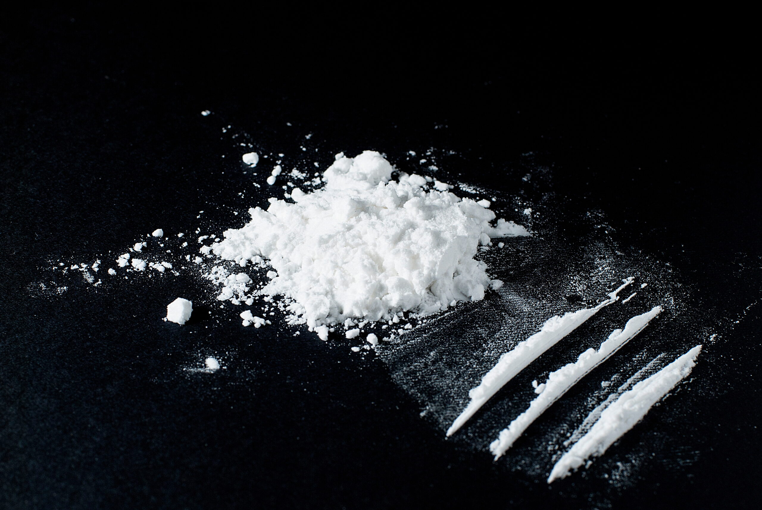 Cocaine divided into paths on a black background Cocaine