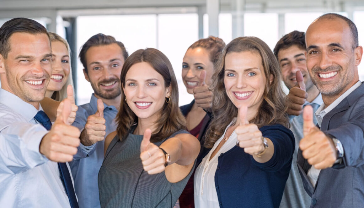 Group of young professionals giving the thumbs up