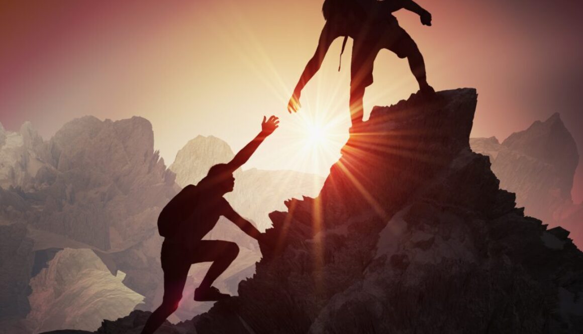 Mountain climbers at sunset atop a peak