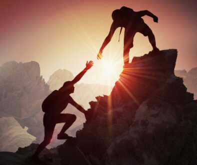 Mountain climbers at sunset atop a peak