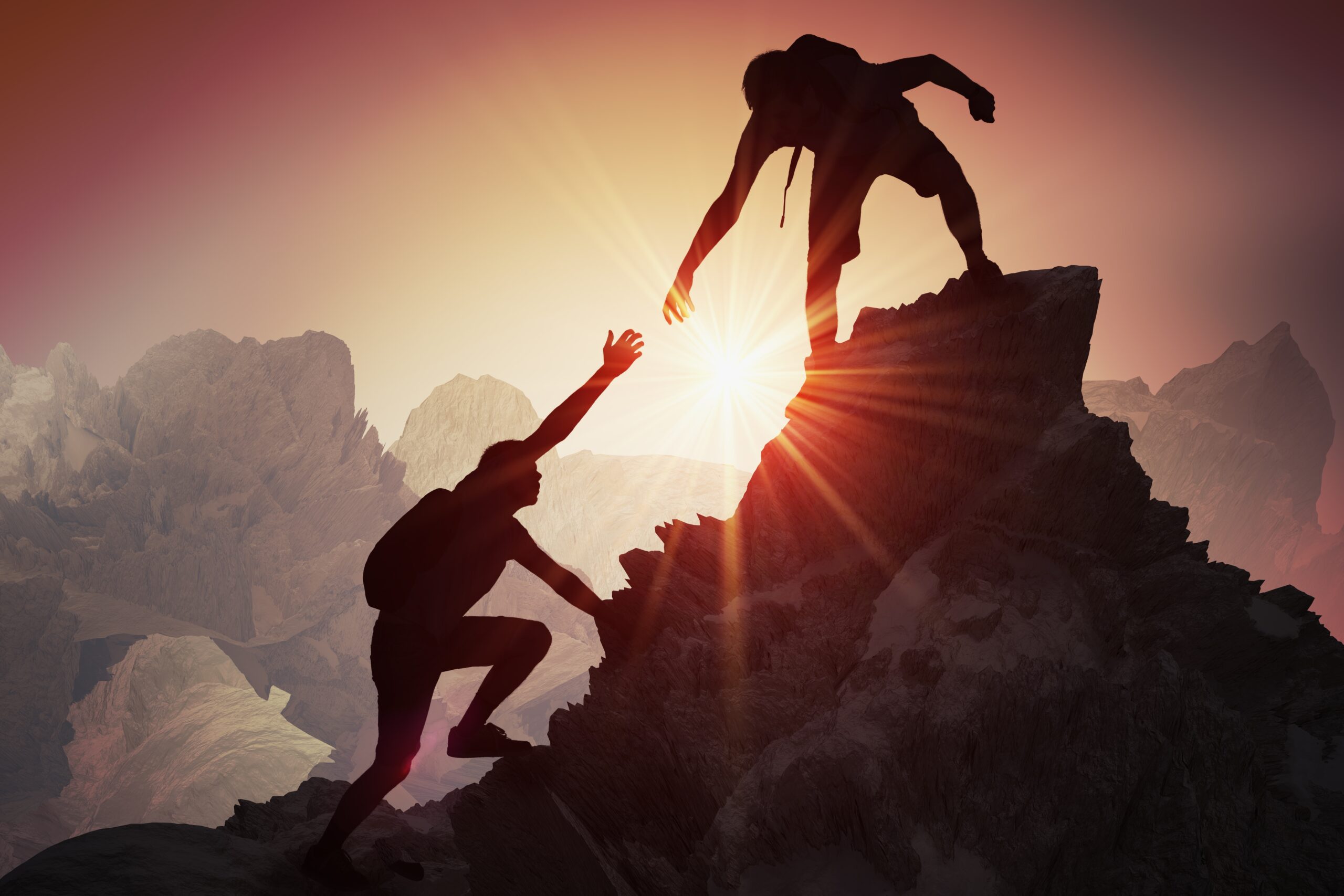 Mountain climbers at sunset atop a peak