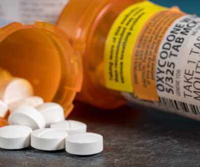Oxycodone narcotic pills spilling out of an open pill container; the image will be used for a post discussing life insurance exclusion riders