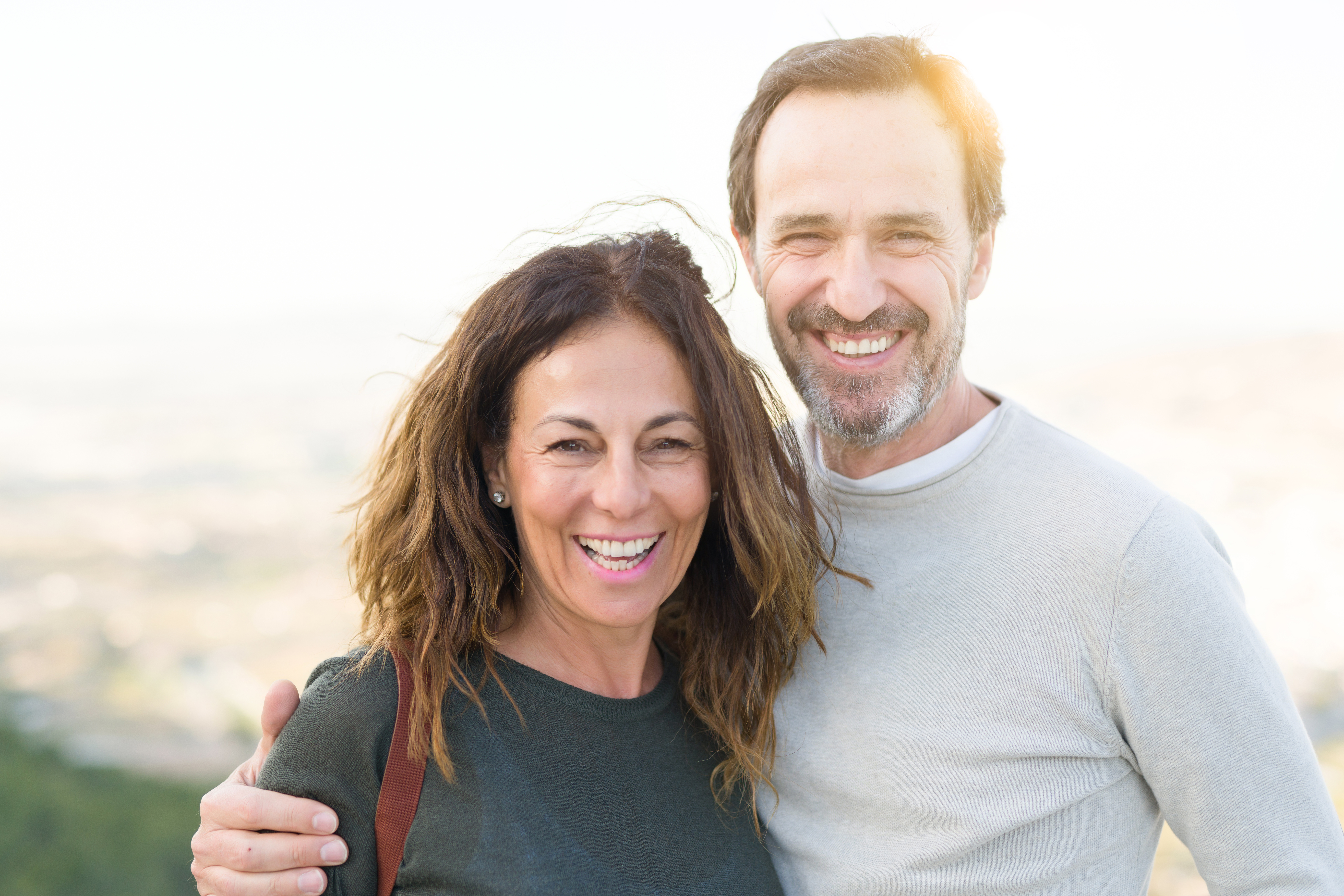 Romantic couple smiling and cuddling on a sunny day Romantic couple smiling and cuddling on a sunny day