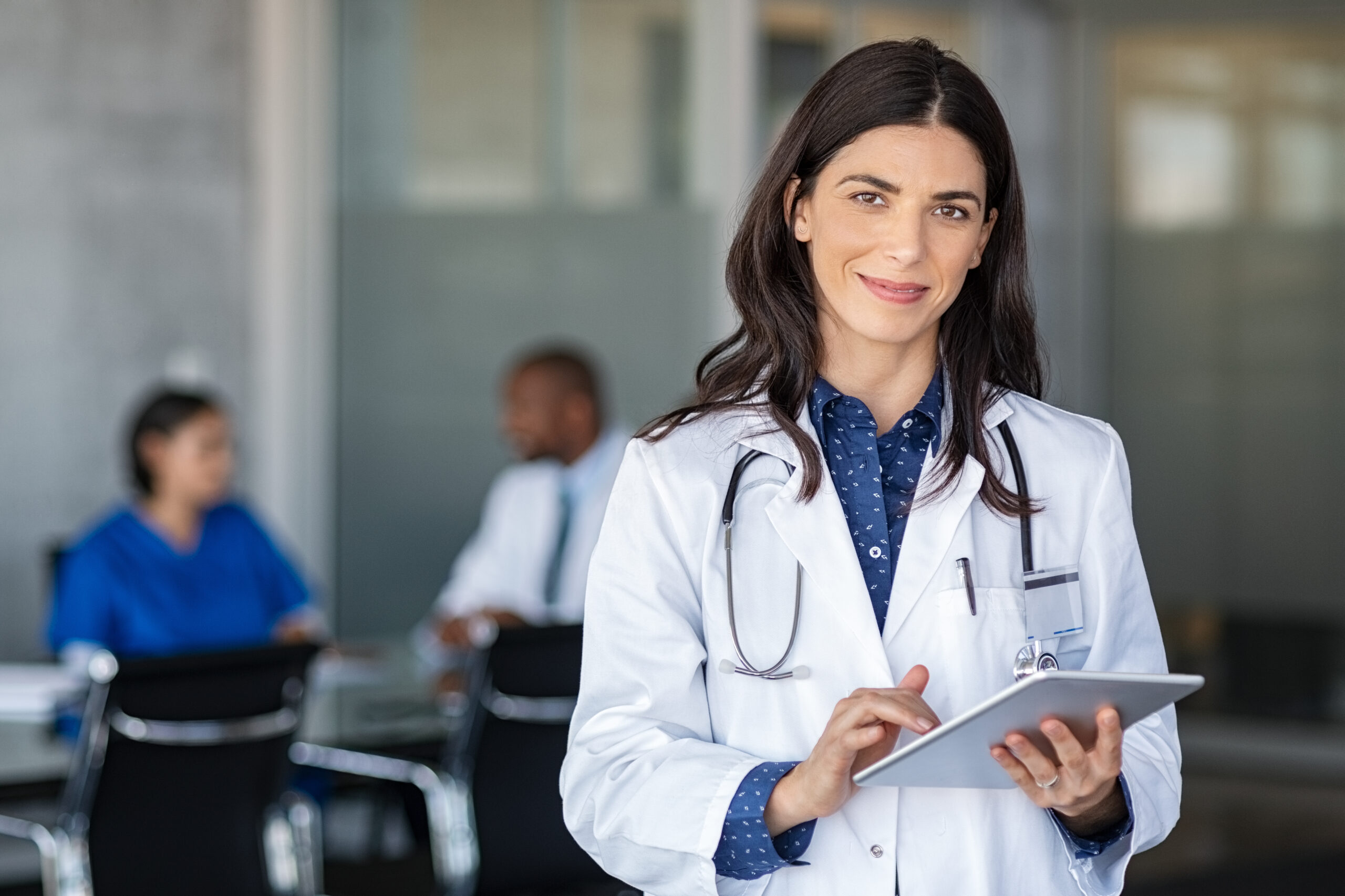 Doctor holding digital tablet at meeting room Doctor getting ready to complete a life insurance medical exam