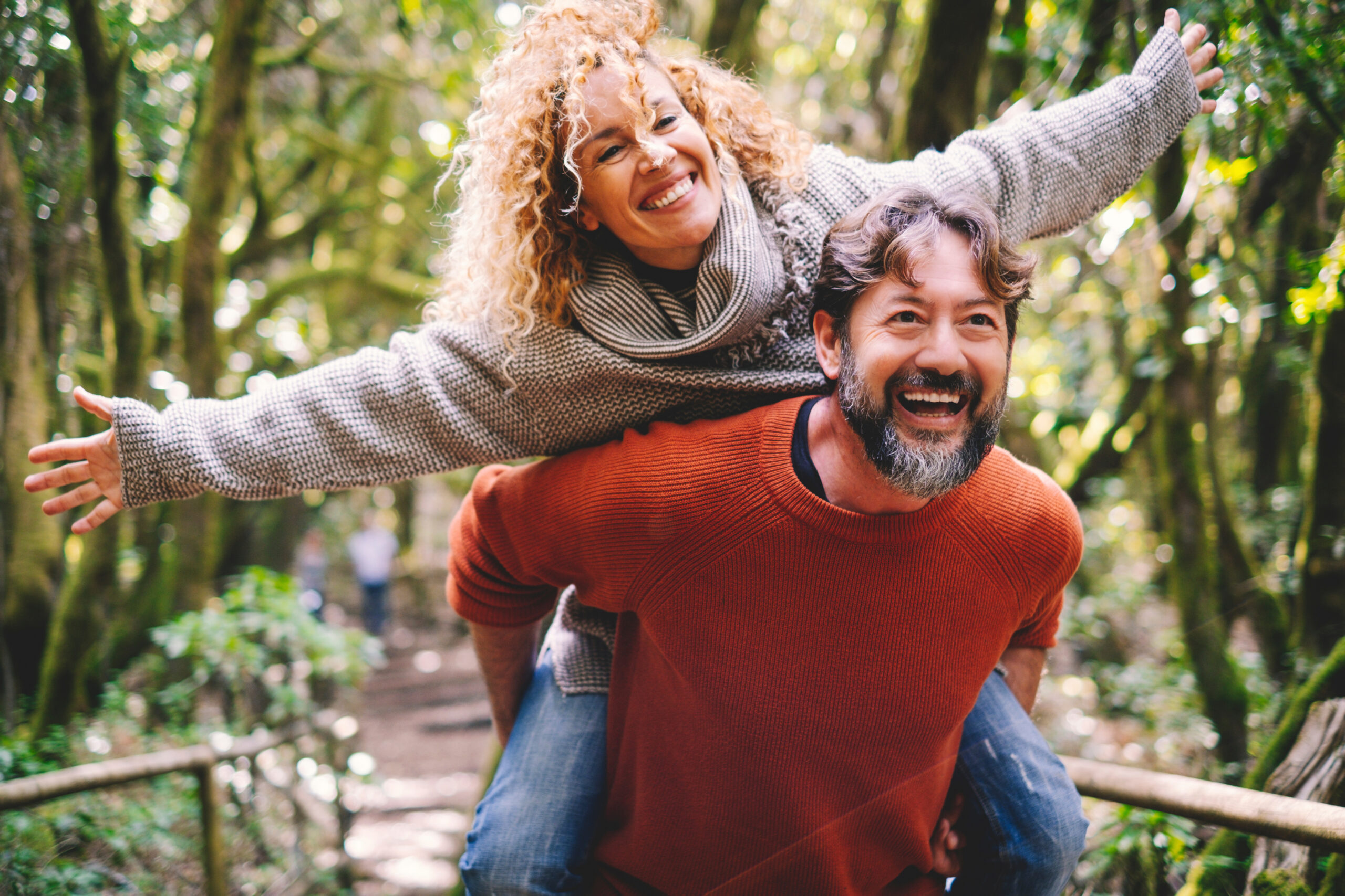 Overjoyed adult couple have fun together at outdoor park in leis Happy middle aged married couple.