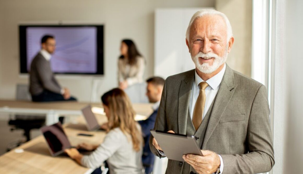 Successful male business owner with iPad looking at the camera.