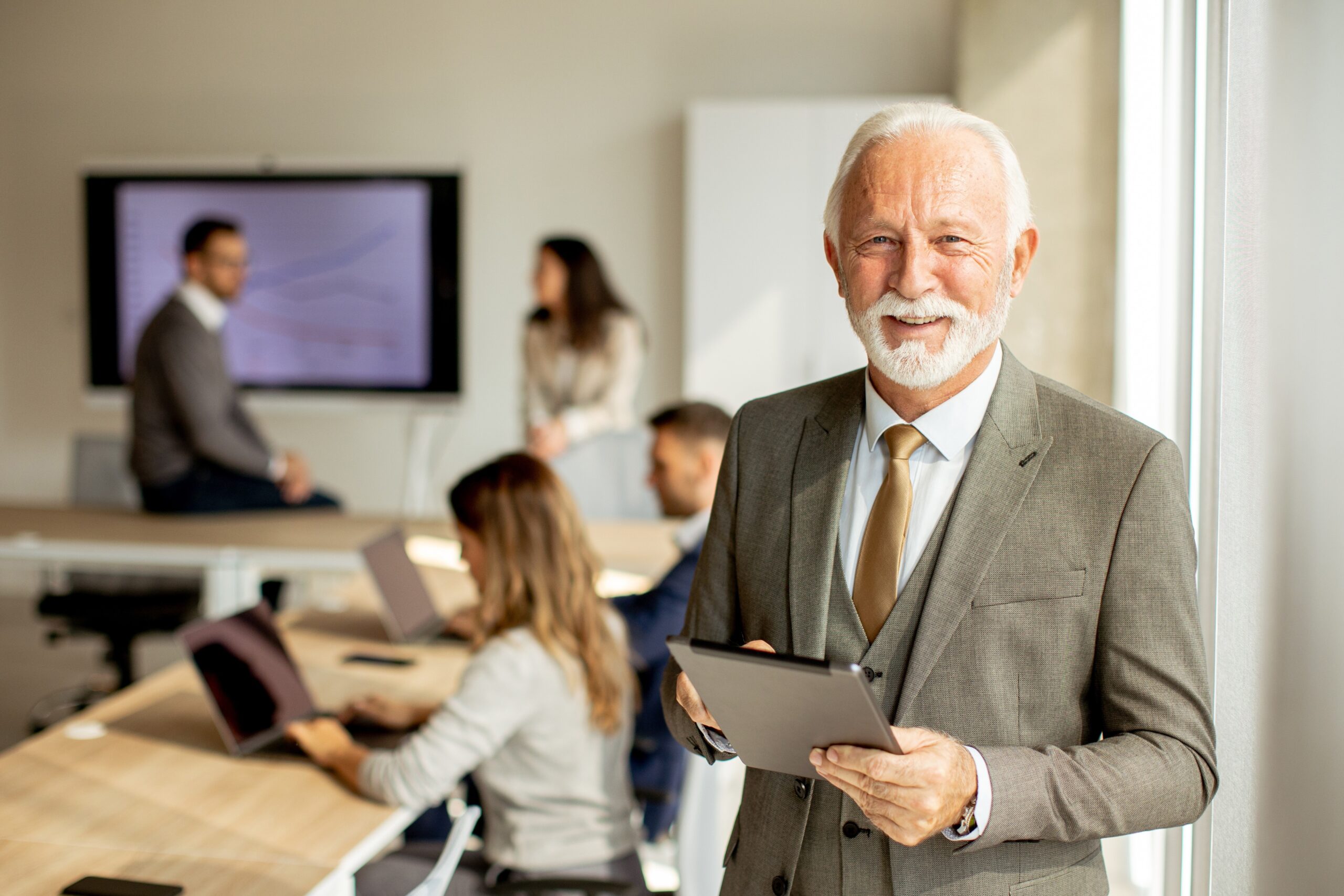 Successful male business owner with iPad looking at the camera.