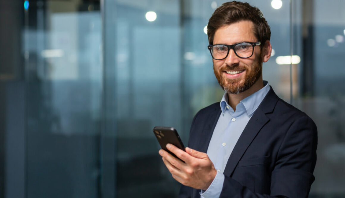 Business Executive holding cell phone smiling