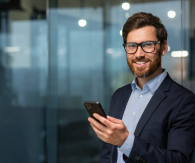 Business Executive holding cell phone smiling