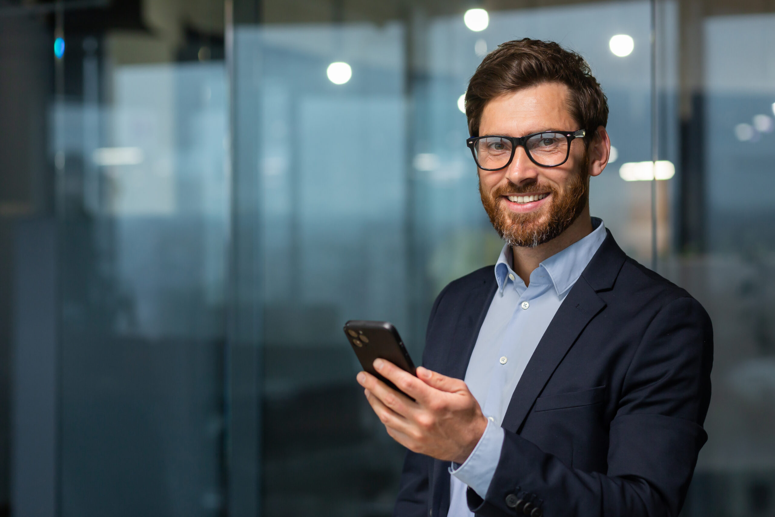 Business Executive holding cell phone smiling