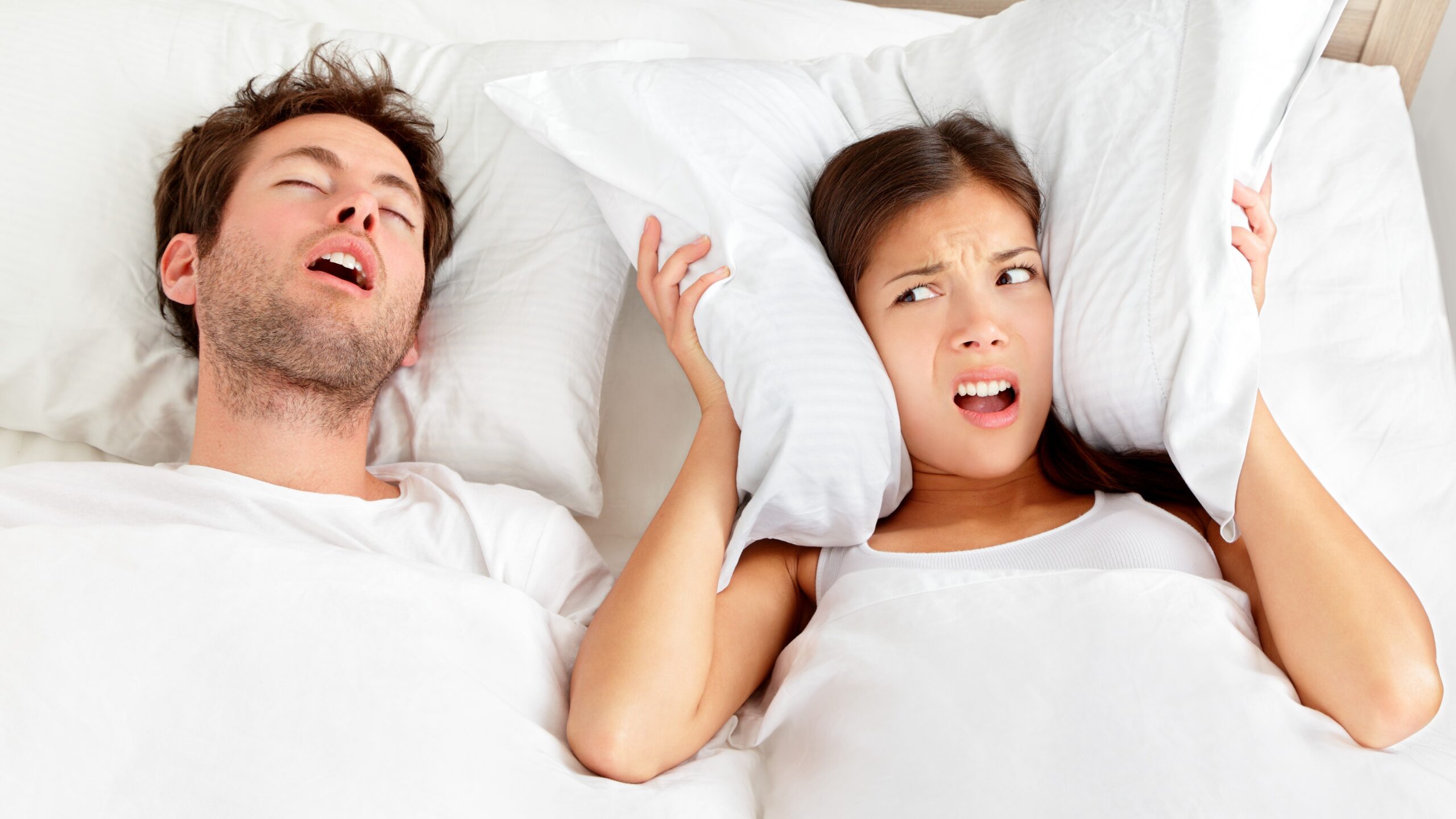 Couple in bed with the man having sleep apnea