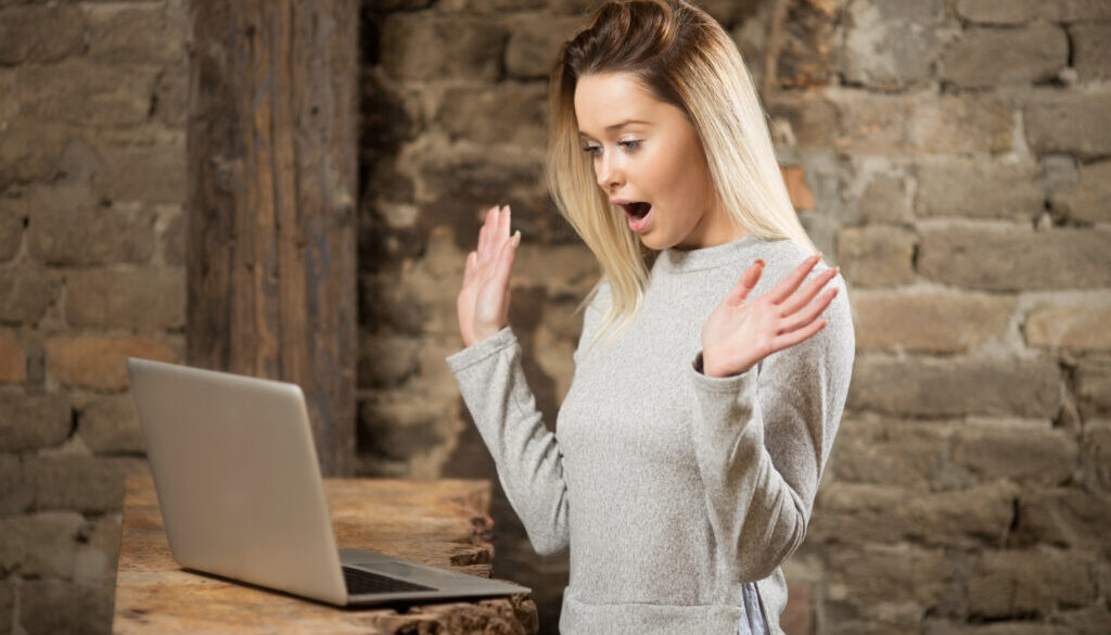 A young blonde woman sees surprising results on computer