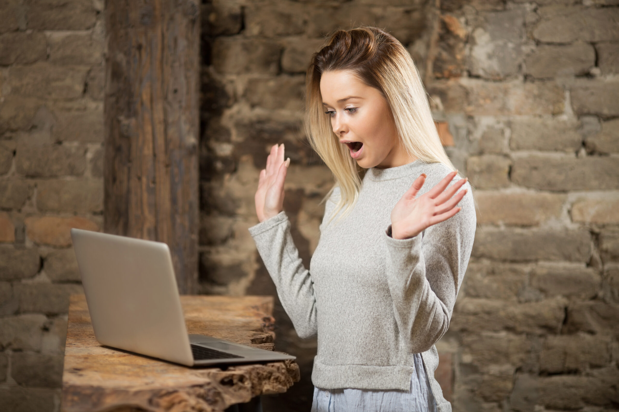 A young blonde woman sees surprising results on computer