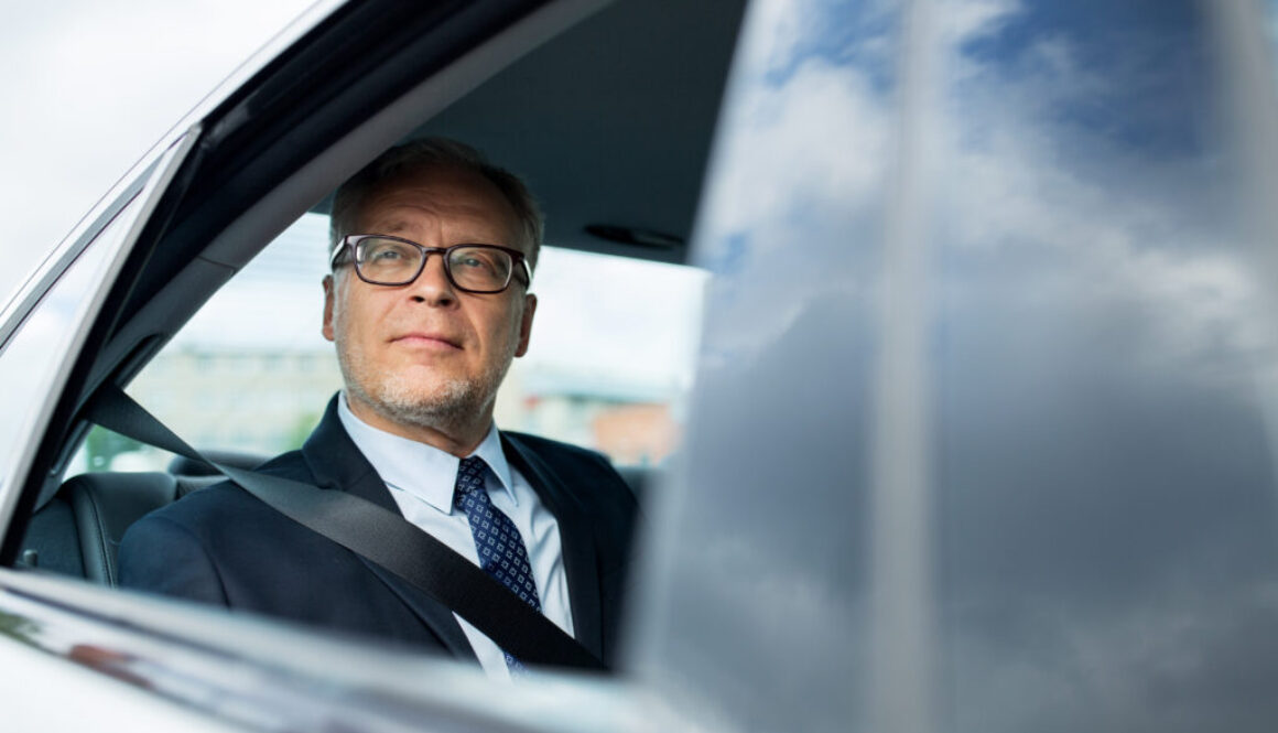 businessman in a car having learned about the potential advantages of layering large life insurance policies