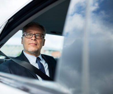 businessman in a car having learned about the potential advantages of layering large life insurance policies